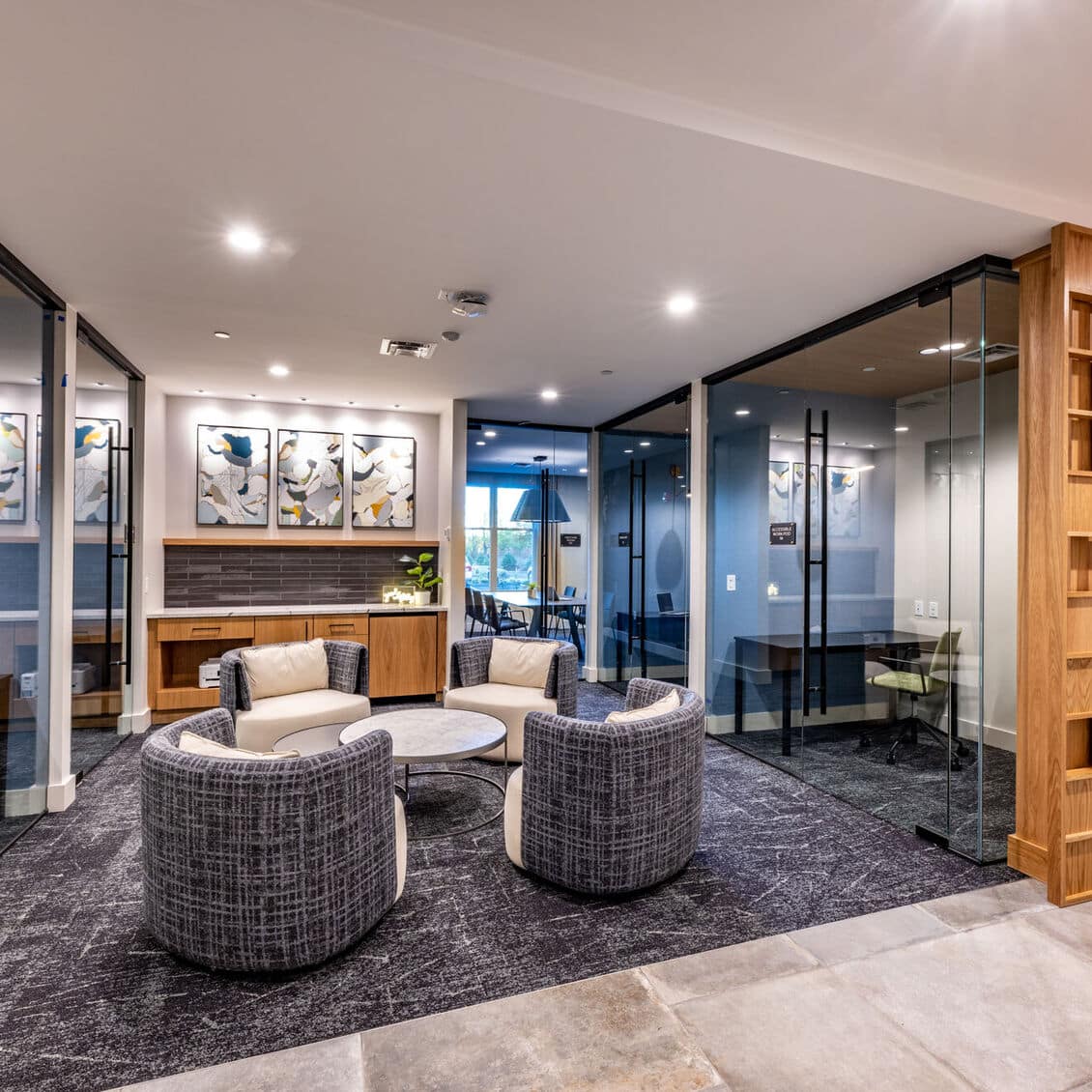 Stylish office seating area surrounded by private workspaces and artistic modern interior design