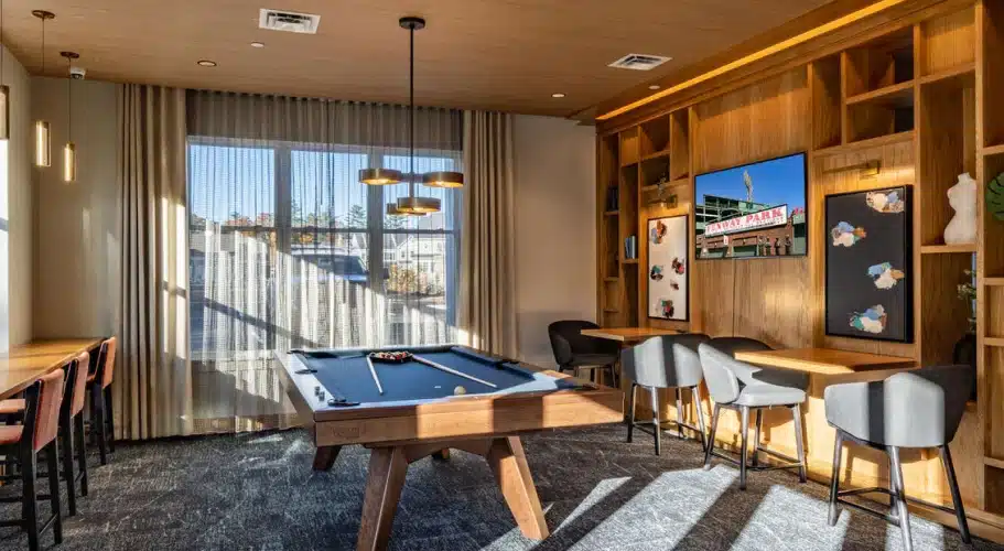 Stylish game room with pool table, lounge seating, and Fenway Park art display