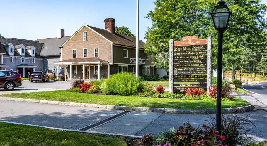 Sudbury Town Square with local business signage, landscaped greenery, and historic-style buildings