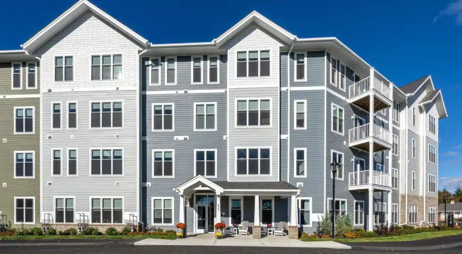 Contemporary apartment building facade with gray siding, multiple windows, and white trim accents