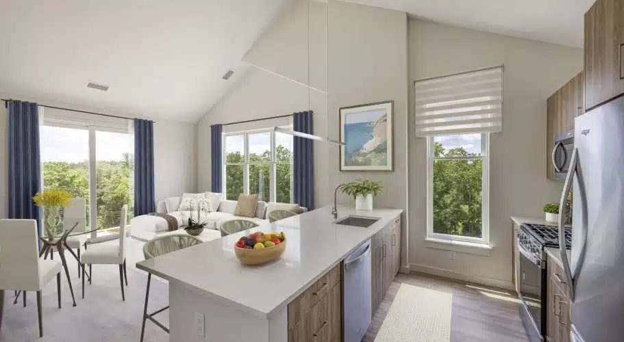 Open kitchen and living area with island seating, dining table, and scenic window views