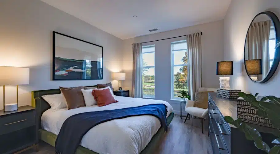 Serene bedroom with large windows, king bed, modern nightstands, and elegant accent lighting