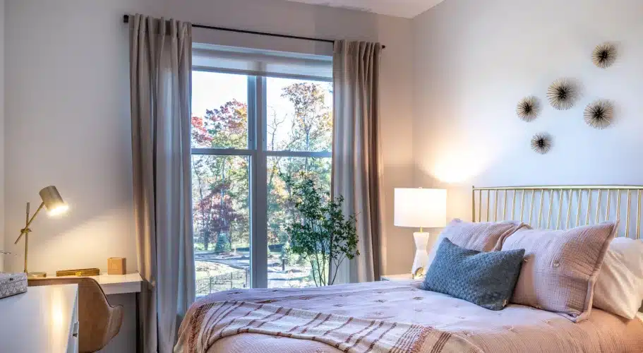 Softly lit bedroom interior with decorative wall art, desk space, and calming natural backdrop