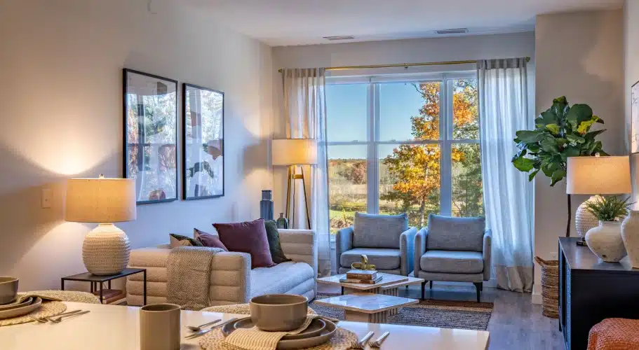 Elegant interior with cozy armchairs, natural light, and vibrant seasonal landscape outside