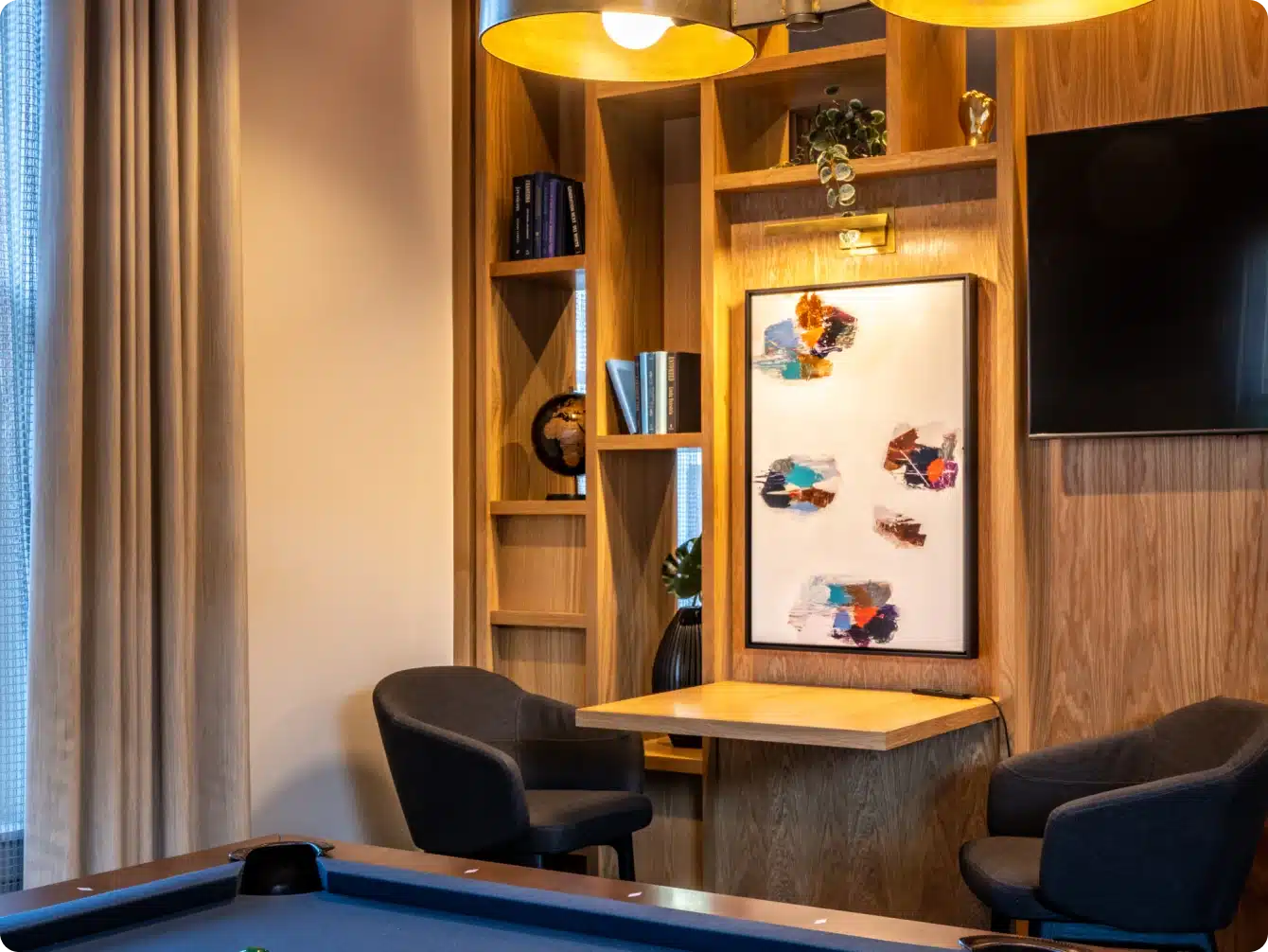 Cozy study corner in game lounge with abstract art, pool table, and wood panel shelving