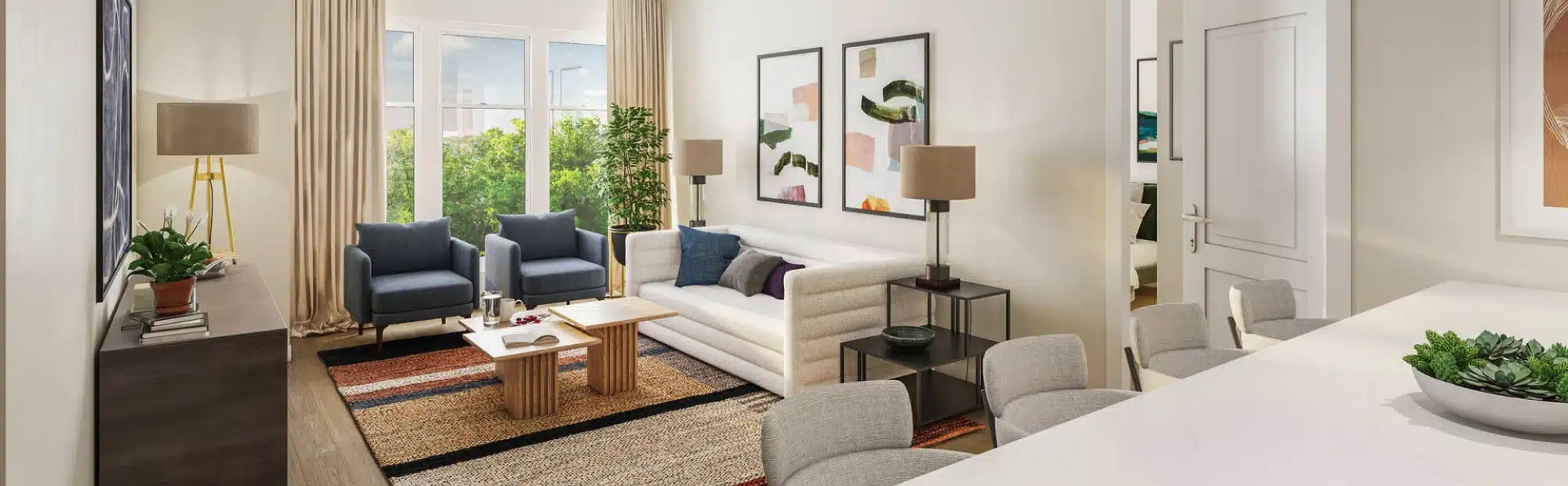 Cozy apartment living room featuring modern art, plush seating, and view of trees through window at The Apartments at Cold Brook Crossing