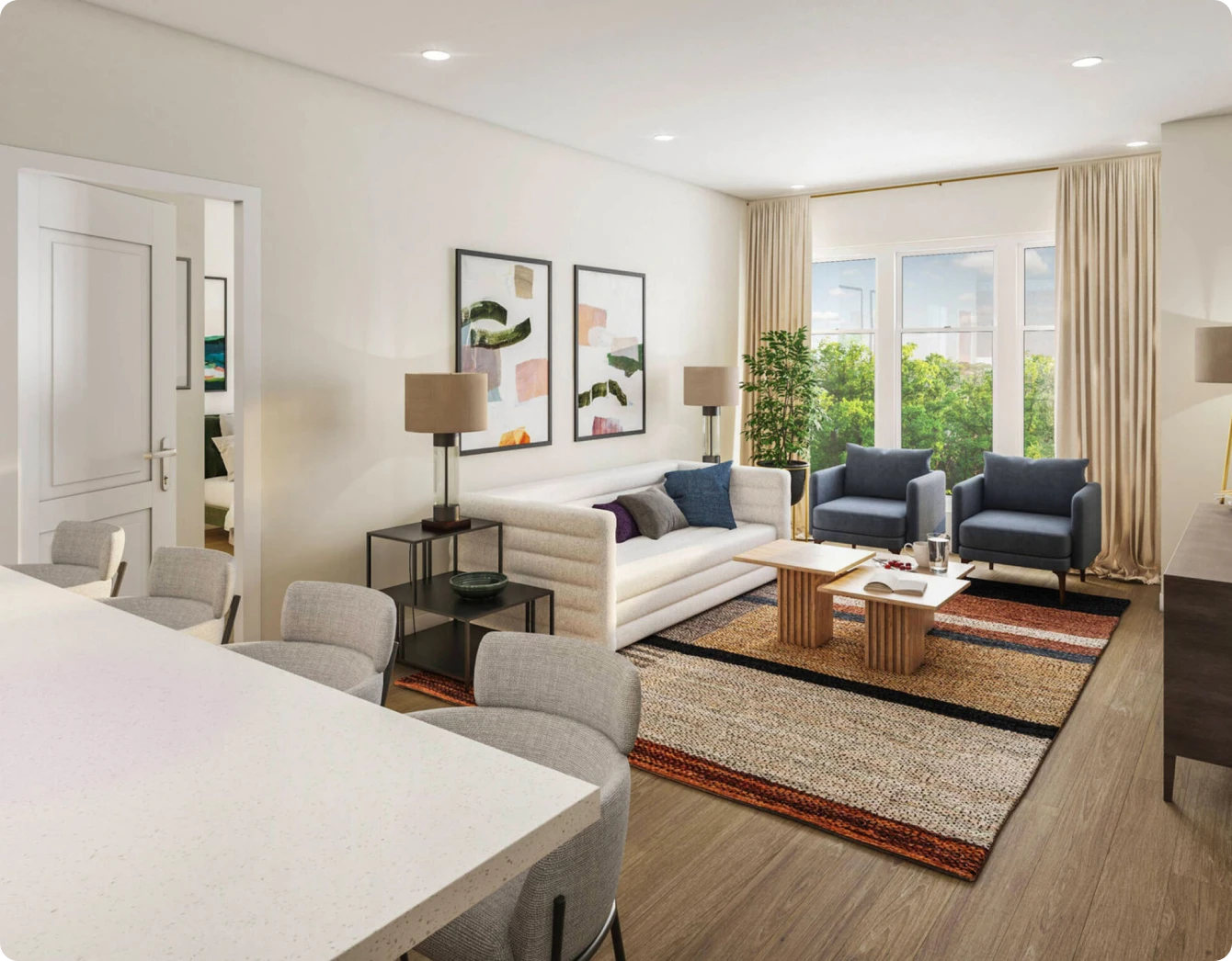 Bright apartment living room with neutral sofa, abstract art, and windows overlooking green scenery