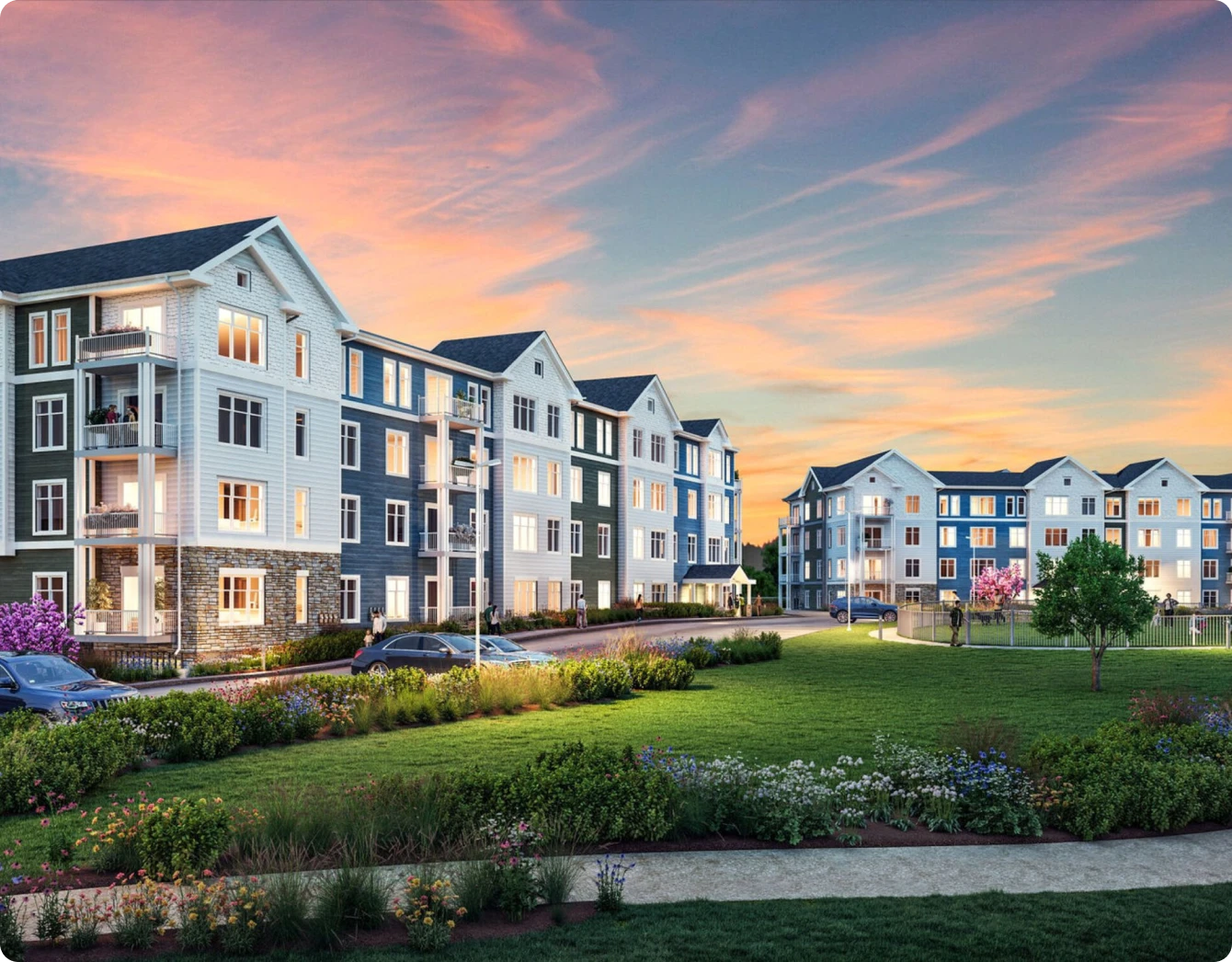 Modern apartment complex with manicured landscaping and sunset sky creating vibrant twilight ambiance