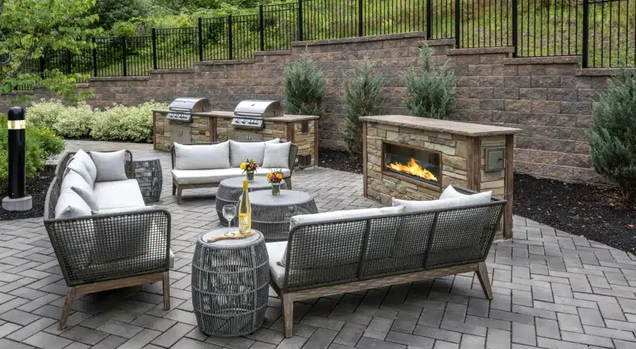 Outdoor fire pit surrounded by outdoor couches on the patio at The Apartments at Cold Brook Crossing in Sudbury, MA.