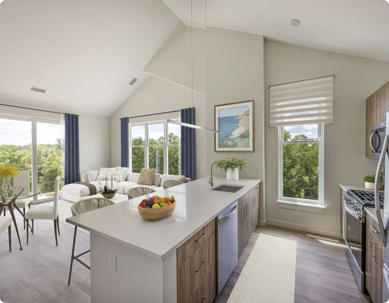 Open kitchen and living area with island seating, dining table, and scenic window views